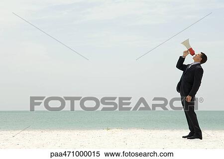 Businessman standing at the beach shouting into megaphone View Large Photo Image Stock Photography - Businessman standing at the beach shouting into megaphone. Fotosearch