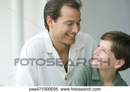 Father and son smiling at each other, close-up View Large Photo Image Stock Photography - Father and son smiling at each other, close-up. Fotosearch