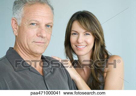 Stock Image - Man and woman smiling at camera, portrait. Fotosearch