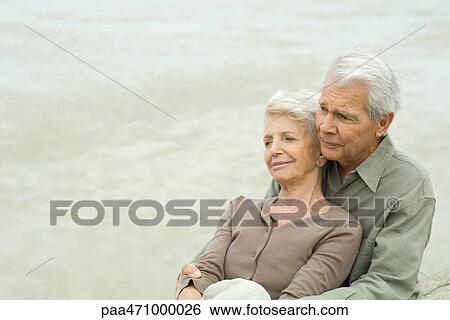 Senior couple sitting together, cheek to cheek, looking away View Large Photo Image Stock Photograph - Senior couple sitting together, cheek to cheek, looking away. Fotosearch