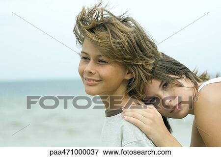 Teenage girl leaning her head against younger brother outdoors, looking at camera, portrait View Large Photo Image Stock Photo - Teenage girl leaning her head against younger brother outdoors, looking at camera, portrait. Fotosearch