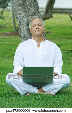 Mature man sitting in grass with laptop computer on lap, eyes closed View Large Photo Image Stock Photograph - Mature man sitting in grass with laptop computer on lap, eyes closed. Fotosearch