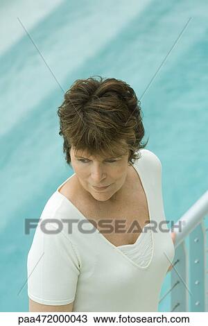 Woman leaning against railing, looking away, high angle view View Large Photo Image Stock Image - Woman leaning against railing, looking away, high angle view. Fotosearch