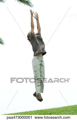 Boy jumping in air to reach foliage View Large Photo Image Stock Image - Boy jumping in air to reach foliage. Fotosearch