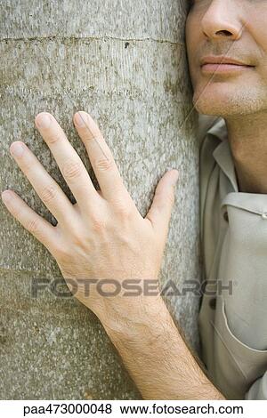 Man embracing tree trunk, cropped view, close-up View Large Photo Image Stock Photo - Man embracing tree trunk, cropped view, close-up. Fotosearch