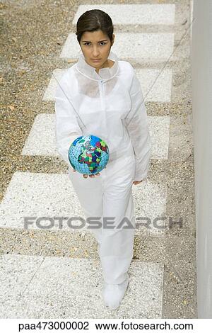 Woman dressed in protective suit carrying globe, looking up at camera View Large Photo Image Stock Image - Woman dressed in protective suit carrying globe, looking up at camera. Fotosearch