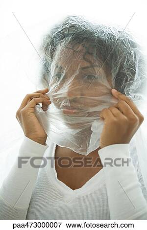 Woman holding plastic bag over head, looking at camera View Large Photo Image Stock Photo - Woman holding plastic bag over head, looking at camera. Fotosearch