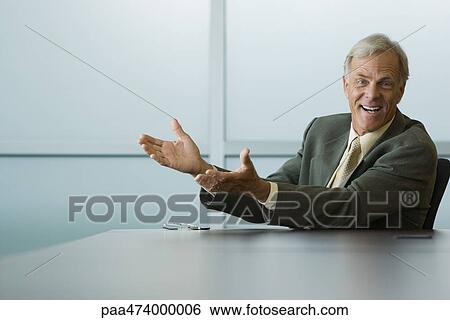 Businessman seated with arms out, smiling at camera View Large Photo Image Stock Photograph - Businessman seated with arms out, smiling at camera. Fotosearch