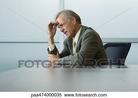 Businessman sitting, holding head, looking away View Large Photo Image Stock Photography - Businessman sitting, holding head, looking away. Fotosearch