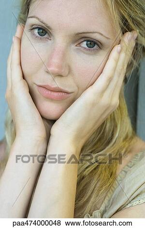 Woman holding face, smiling at camera View Large Photo Image Stock Photo - Woman holding face, smiling at camera. Fotosearch