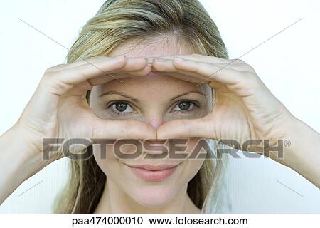 Woman looking at camera through finger frame, close-up View Large Photo Image Stock Image - Woman looking at camera through finger frame, close-up. Fotosearch