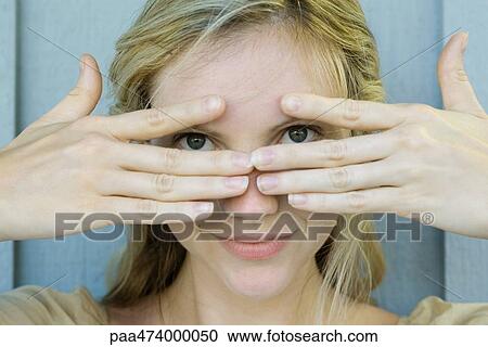 Woman peeking through fingers at camera View Large Photo Image Stock Image - Woman peeking through fingers at camera. Fotosearch