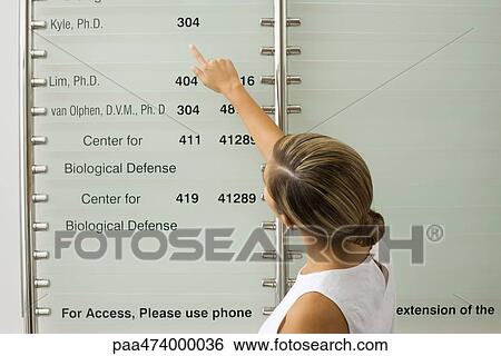 Woman pointing at sign, rear view View Large Photo Image Stock Photograph - Woman pointing at sign, rear view. Fotosearch