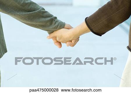 Stock Photo - Couple holding hands, cropped view, close-up. Fotosearch