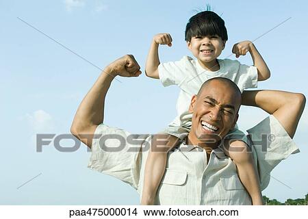 Father carrying son on shoulders, both flexing arm muscles and smiling at camera View Large Photo Image Picture - Father carrying son on shoulders, both flexing arm muscles and smiling at camera. Fotosearch