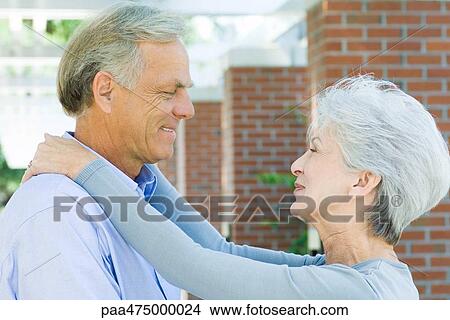 Mature couple smiling at each other, face to face, side view View Large Photo Image Picture - Mature couple smiling at each other, face to face, side view. Fotosearch
