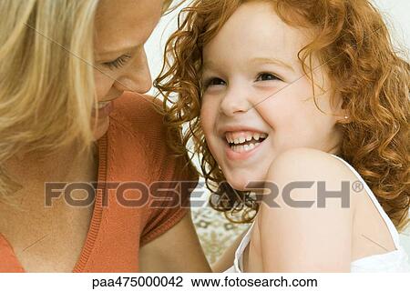 Mother and daughter laughing together, close-up View Large Photo Image Stock Image - Mother and daughter laughing together, close-up. Fotosearch