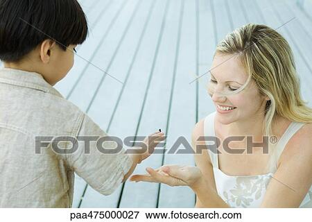 Mother and son looking down at insect crawling on boy's hand View Large Photo Image Stock Photo - Mother and son looking down at insect crawling on boy's hand. Fotosearch