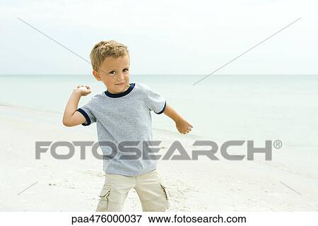 Boy at the beach throwing seashell, smiling at camera View Large Photo Image Stock Photo - Boy at the beach throwing seashell, smiling at camera. Fotosearch
