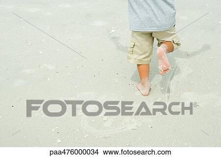 Child running barefoot on sand, cropped rear view View Large Photo Image Picture - Child running barefoot on sand, cropped rear view. Fotosearch