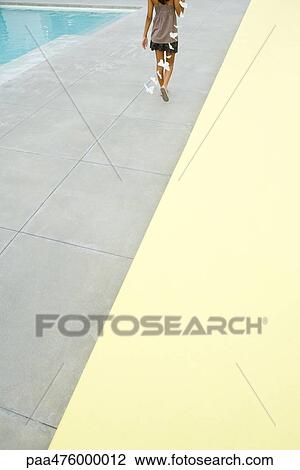 Teenage girl walking alongside swimming pool carrying butterfly streamer, cropped rear view View Large Photo Image Stock Image - Teenage girl walking alongside swimming pool carrying butterfly streamer, cropped rear view. Fotosearch
