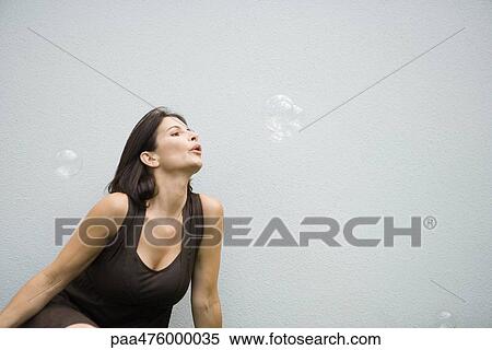 Woman blowing bubbles, waist up View Large Photo Image Stock Photography - Woman blowing bubbles, waist up. Fotosearch
