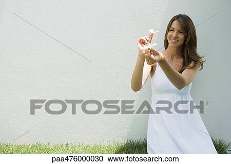 Woman in sundress holding fake butterflies, smiling View Large Photo Image Stock Image - Woman in sundress holding fake butterflies, smiling. Fotosearch