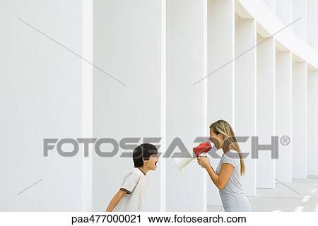 Boy and woman shouting at each other, woman using megaphone View Large Photo Image Stock Image - Boy and woman shouting at each other, woman using megaphone. Fotosearch