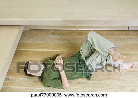 Boy lying on floor with book over face View Large Photo Image Stock Photography - Boy lying on floor with book over face. Fotosearch