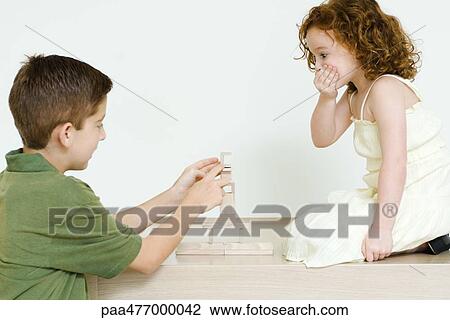 Boy stacking blocks while little sister watches, hand over mouth View Large Photo Image Stock Image - Boy stacking blocks while little sister watches, hand over mouth. Fotosearch