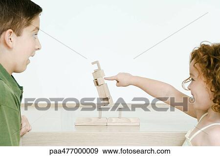 Little girl knocking over blocks while brother watches in surprise View Large Photo Image Stock Photo - Little girl knocking over blocks while brother watches in surprise. Fotosearch