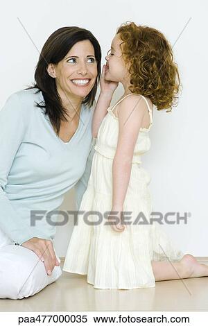 Stock Photography - Little girl whispering to mother. Fotosearch