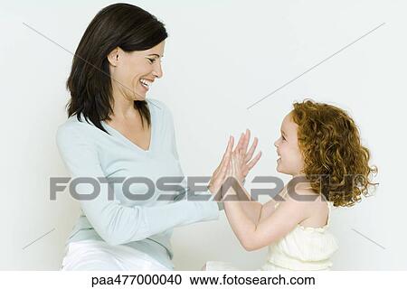 Woman and little girl playing clapping game, side view View Large Photo Image Stock Image - Woman and little girl playing clapping game, side view. Fotosearch