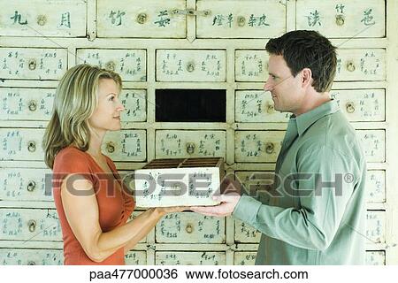 Woman and man holding drawer between them, smiling at each other View Large Photo Image Stock Photograph - Woman and man holding drawer between them, smiling at each other. Fotosearch