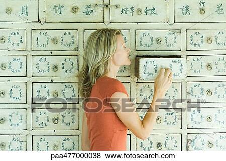 Woman opening drawer in piece of furniture View Large Photo Image Stock Photo - Woman opening drawer in piece of furniture. Fotosearch