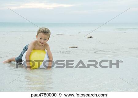 Little boy lying on beach ball, smiling at camera, full length View Large Photo Image Stock Photo - Little boy lying on beach ball, smiling at camera, full length. Fotosearch