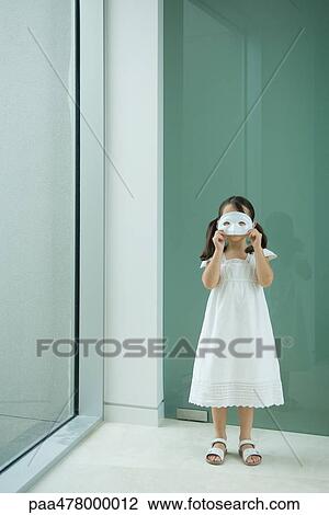 Little girl holding mask in front of eyes View Large Photo Image Stock Image - Little girl holding mask in front of eyes. Fotosearch
