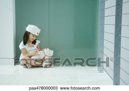 Little girl in nurse hat giving teddy bear shot View Large Photo Image Stock Image - Little girl in nurse hat giving teddy bear shot. Fotosearch