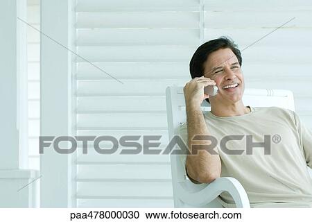 Man using cell phone on porch, smiling View Large Photo Image Stock Image - Man using cell phone on porch, smiling. Fotosearch