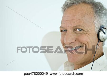 Mature man wearing headphones, smiling at camera View Large Photo Image Stock Photo - Mature man wearing headphones, smiling at camera. Fotosearch