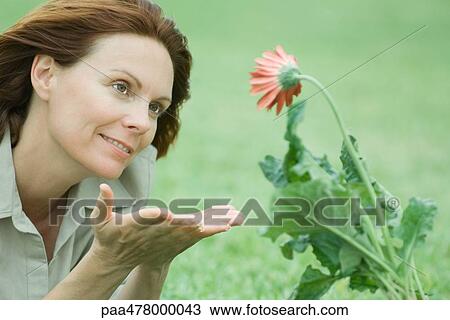 Woman beholding flower View Large Photo Image Stock Image - Woman beholding flower. Fotosearch