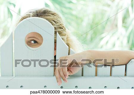 Stock Photo - Woman looking through hole . Fotosearch