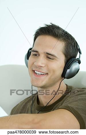 Young man wearing headphones, smiling View Large Photo Image Stock Photo - Young man wearing headphones, smiling. Fotosearch