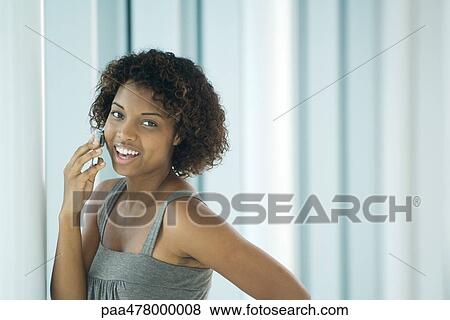 Stock Photo - Young woman using cell phone. Fotosearch