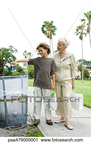 Boy and grandmother standing by trash can, boy throwing away drink can View Large Photo Image Stock Image - Boy and grandmother standing by trash can, boy throwing away drink can. Fotosearch
