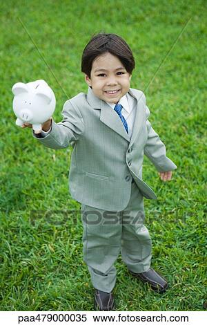 Little boy wearing full suit, holding up piggy bank, smiling at camera, full length View Large Photo Image Stock Photography - Little boy wearing full suit, holding up piggy bank, smiling at camera, full length. Fotosearch
