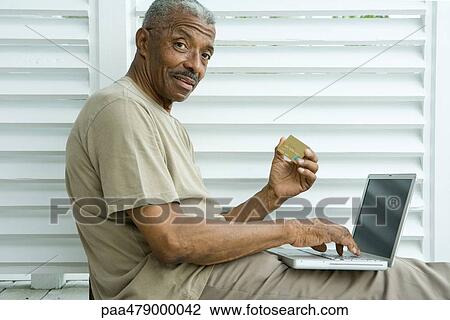 Senior man making credit card purchase online, smiling at camera View Large Photo Image Stock Image - Senior man making credit card purchase online, smiling at camera. Fotosearch