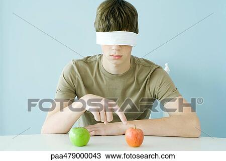 Teen boy wearing blindfold, pointing to red apple View Large Photo Image Stock Image - Teen boy wearing blindfold, pointing to red apple. Fotosearch