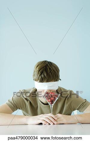 Teen boy wearing blindfold, smelling glass full of cherries View Large Photo Image Picture - Teen boy wearing blindfold, smelling glass full of cherries. Fotosearch