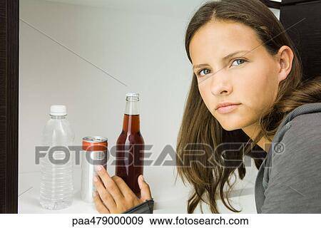 Teen girl next to variety of drinks, reaching for bottled soft drink View Large Photo Image Stock Photo - Teen girl next to variety of drinks, reaching for bottled soft drink. Fotosearch